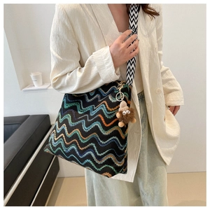 Dettaglio della borsa tote colorata a zigzag con ciondolo a mostro e tracolla a V