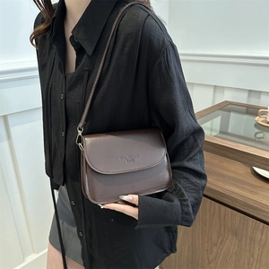 Sacoche marron foncé en cuir avec bandoulière réglable et finitions métalliques dorées