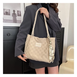 Detail der beigen Tote Bag mit Schachbrettmuster, gewebten Griffen und stilvollem Seidenschal