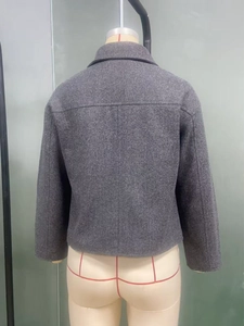 Vista posteriore della giacca di lana grigio scuro con trama in tweed e taglio a H