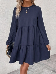 Détail de la texture côtelée bleu marine sur la robe à manches longues et volants