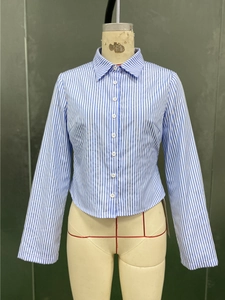 Détail de la chemise à rayures bleues et blanches à manches longues et col pointu