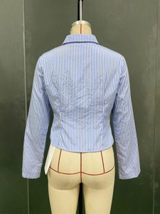 Détail du dos d'une chemise rayée bleue et blanche à manches longues en coupe ajustée