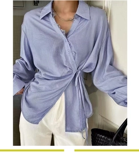 Detailed view of light purple wrap shirt featuring delicate lace trim on the V-neckline