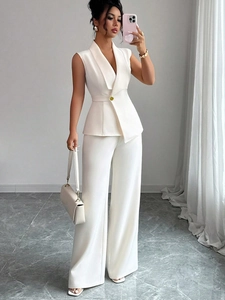 Close-up of elegant white sleeveless vest with belt and matching high-waist wide-leg pants