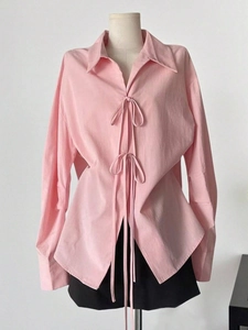 Vue détaillée d'une chemise rose à manches longues avec doubles lacets et tissu texturé