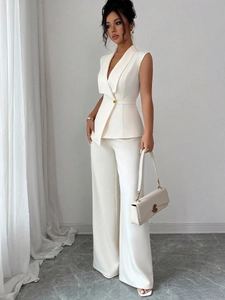 Detail of elegant white vest suit featuring shawl lapel and gold button with wide pants