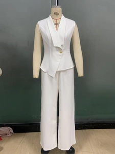 Detail of white two-piece suit with asymmetric sleeveless vest and wide-leg trousers
