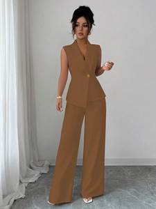 Detail showing the single gold button closure on the brown vest's slim waistline