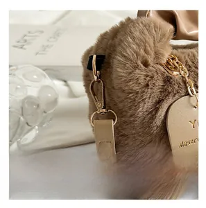 Close-up of premium gold metal hardware and heart leather tag on brown plush bag