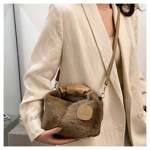 Close-up of brown plush handbag with ruched handle and 'You deserve better' tag