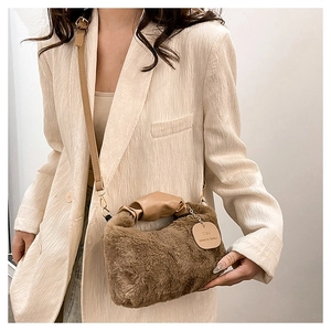 Close-up of brown plush faux fur bag with leather tag and elegant gold hardware details