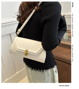 Détail du sac bandoulière en cuir mat blanc doté d'une boucle ovale dorée élégante