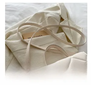 Vue détaillée du sac à bandoulière matelassé blanc avec fine sangle sur blazer