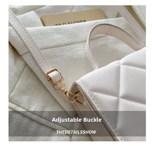 Détail du sac matelassé blanc montrant la boucle dorée réglable et les ferrures