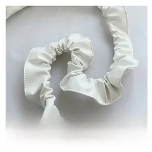 Détail d'une bandoulière blanche plissée en similicuir avec coutures visibles pour sacs
