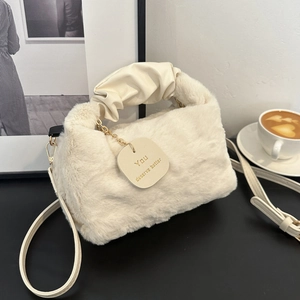 Chic beige faux fur shoulder bag with ruched handle and heart charm in a lifestyle setting