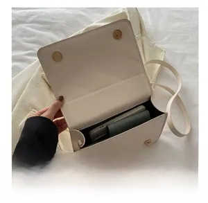 Vue intérieure du sac bandoulière beige matelassé montrant l'espace pour téléphone