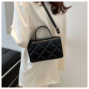 Détail d'un sac bandoulière noir en cuir PU matelassé avec poignée et finitions dorées