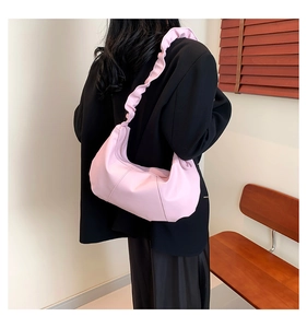 Détail du sac bandoulière rose avec bandoulière à volants et plis élégants en cuir souple