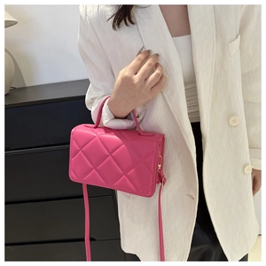 Détail du sac à main rose matelassé avec ferrures dorées et bandoulière amovible