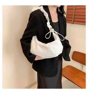 Détail d'un sac nuage blanc avec bandoulière à volants et nœuds de serrage élégants