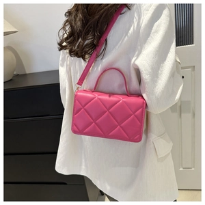 Détail du sac à bandoulière matelassé rose avec sangle réglable et finition texturée