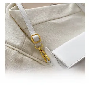 Detail of premium golden adjustable metal buckle on white leather crossbody bag