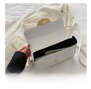 Interior view showing the capacity of a white leather flap bag holding a smartphone