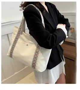 Detail of cream tote bag featuring a colorful geometric jacquard woven shoulder strap