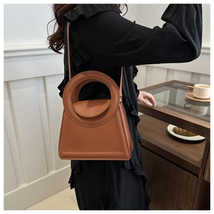 Brown retro handbag with unique large circular handle and structured trapezoid design