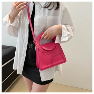 Magenta square handbag with ring handle shown on model wearing white shirt and black skirt