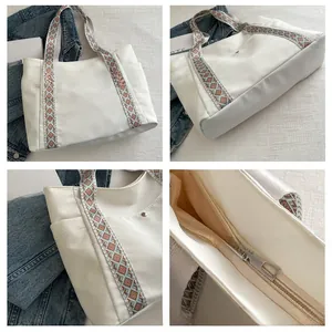 Detail view of large white tote bag with ethnic geometric strap and side pocket design