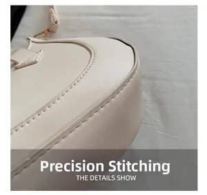 Detail shot of precision stitching on the cream crescent shoulder bag bottom curvature
