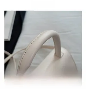 Macro shot of comfortable leather handle with fine stitching on beige handbag