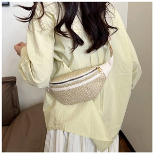 Détail du sac ceinture en paille tressée avec bandoulière réglable et zip en métal