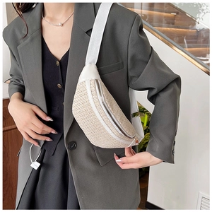 Détail d'un sac de poitrine texturé crème avec bandoulière sur un blazer gris chic