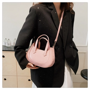 Detail view of pink crossbody bag with triangular stitching and detachable strap
