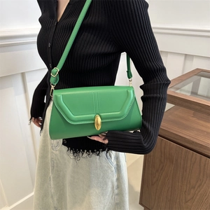 Sac à bandoulière en cuir vert vif rétro avec fermoir doré porté par un mannequin