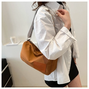 Detail of orange nylon Boston bag featuring a stylish wide patterned woven strap