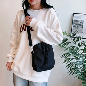Minimalistische schwarze Nylon-Umhängetasche mit Kordelzug, präsentiert am Model