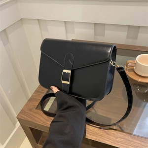 Minimalist black leather crossbody bag with flap cover and strap detail for women