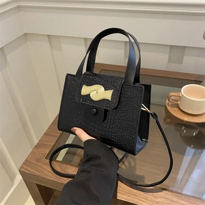 Fashionable black crocodile pattern shoulder bag with elegant gold wavy hardware detail