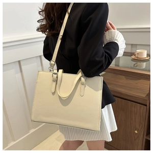 Detailed view of cream white faux leather tote bag with silver hardware and shoulder strap