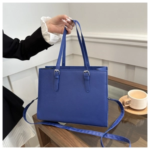 Detail of dark blue tote bag showing Saffiano texture and detachable shoulder strap