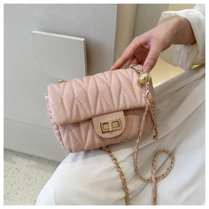 Detail of pink quilted saddle bag with V-shaped wave pattern and gold chain strap