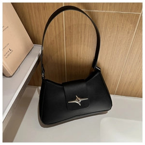 Dettaglio della borsa baguette nera minimalista con fibbia in metallo a forma di stella