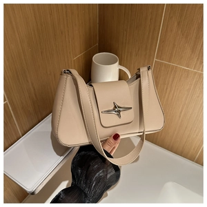 Dettaglio della borsa baguette beige con fibbia a stella argento e texture in pelle opaca