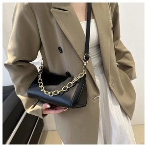 Detail of black matte leather shoulder bag with decorative gold chain and adjustable strap