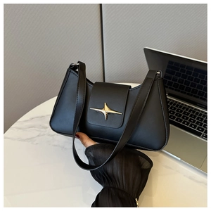 Dettaglio della borsa baguette nera in pelle con fibbia in metallo dorato a stella